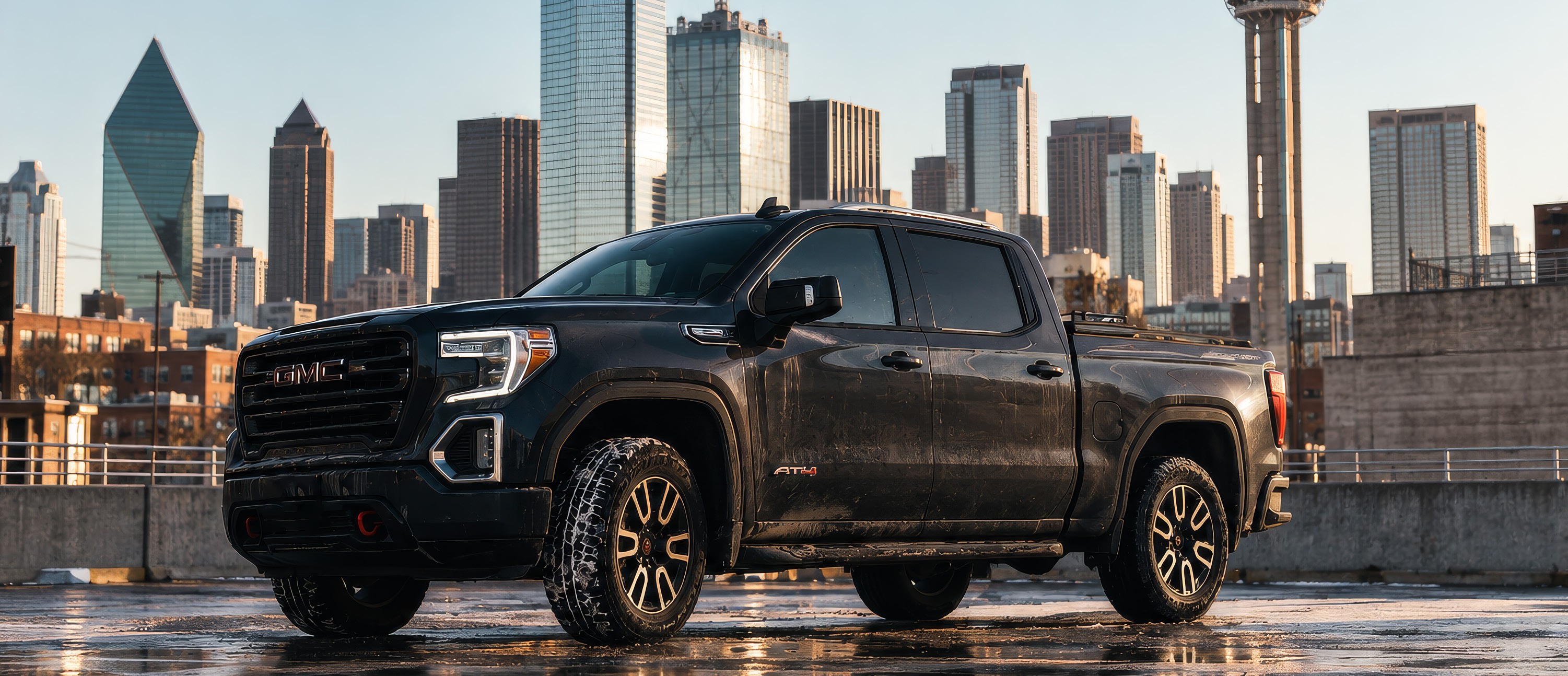 Black GMC diesel truck in front of the Dallas skyline